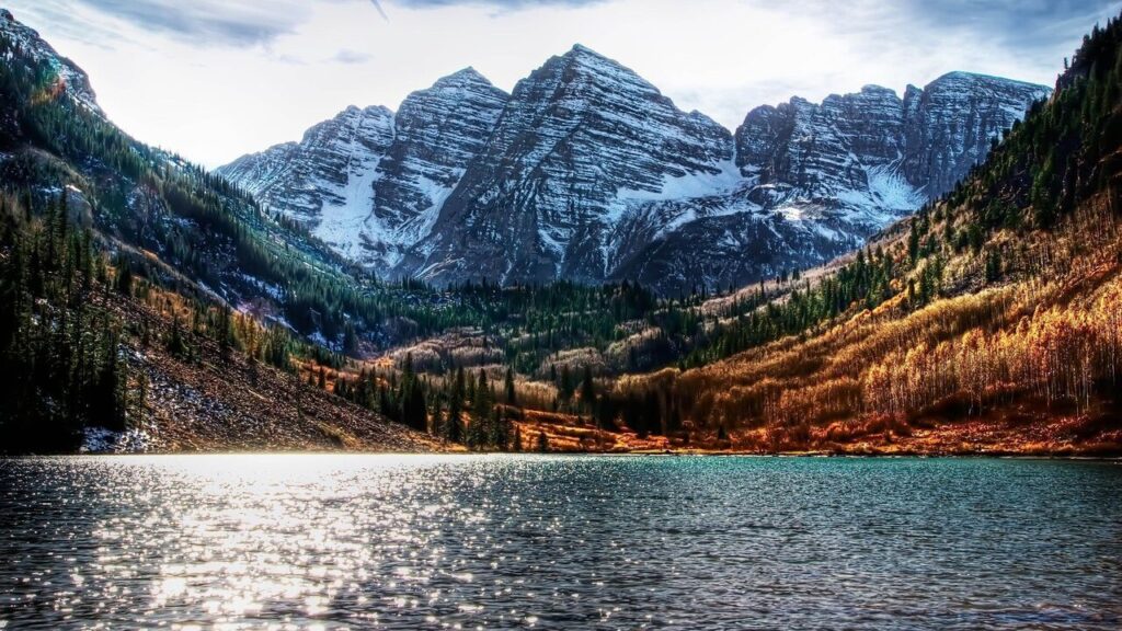 Snow-capped Colorado mountain peaks at golden hour representing City to Summit Courier's Denver to mountain delivery routes