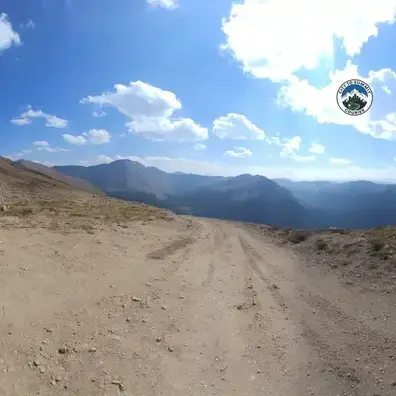 Snow-covered Colorado mountain road in winter conditions representing City to Summit Courier's storm-tested year-round mountain delivery expertise